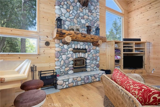 10820 Bonita Way, Wofford Heights, CA 93285 - living room featuring wood walls, hardwood / wood-style floors, a high ceiling, and a stone fireplace