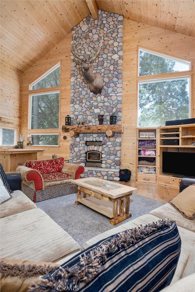 10820 Bonita Way, Wofford Heights, CA 93285 - living area with wood walls, high vaulted ceiling, wooden ceiling with exposed beams, wood finished floors, and a stone fireplace