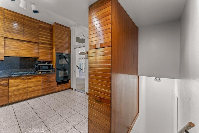 30211 Via Rivera, Rancho Palos Verdes, CA 90275 - kitchen featuring stainless steel microwave, gas cooktop, brown cabinets, light tile patterned flooring, and decorative backsplash