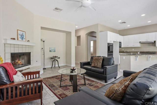 435 Sandalwood Ct, Encinitas, CA 92024 - living area featuring ceiling fan, a tile fireplace, baseboards, arched walkways, and recessed lighting