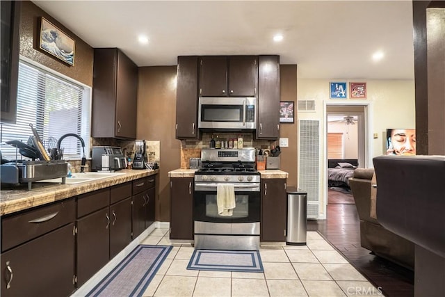 11737 Bellman Ave, Downey, CA 90241 - kitchen with appliances with stainless steel finishes, a heating unit, a sink, tasteful backsplash, and dark brown cabinetry