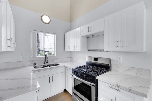4406 Cahuenga Blvd, Toluca Lake, CA 91602 - kitchen with gas range, a sink, light stone countertops, and white cabinetry