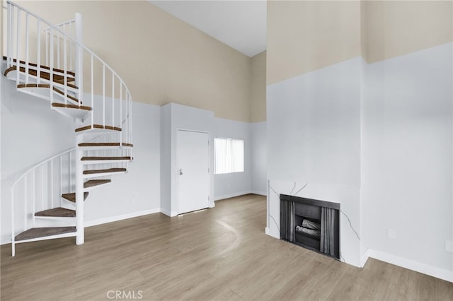 4406 Cahuenga Blvd, Toluca Lake, CA 91602 - unfurnished living room with a high ceiling, stairway, wood finished floors, and baseboards
