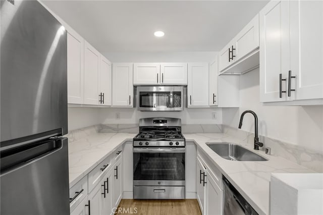 4406 Cahuenga Blvd, Toluca Lake, CA 91602 - kitchen with appliances with stainless steel finishes, a sink, white cabinets, recessed lighting, and light stone counters