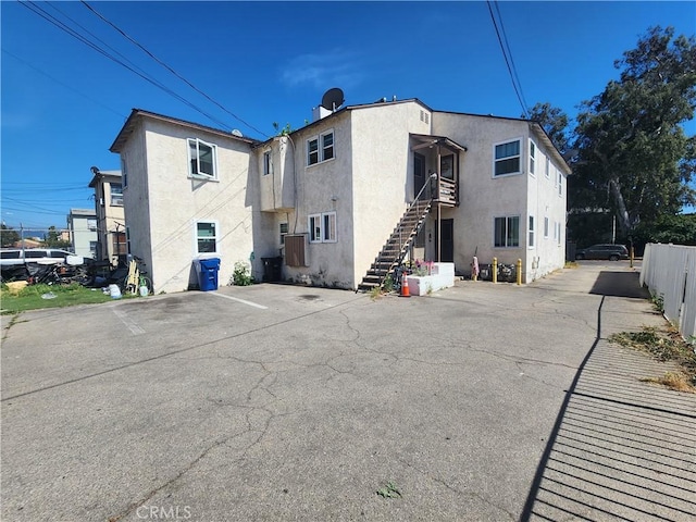 11633 Friar St, North Hollywood, CA 91606 - back of house with stucco siding, stairway, and uncovered parking