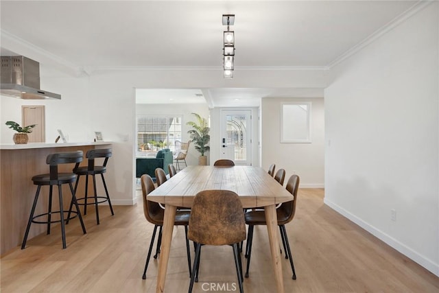 4920 Island View St, Oxnard, CA 93035 - dining area with crown molding, light wood finished floors, baseboards, and bar with sink
