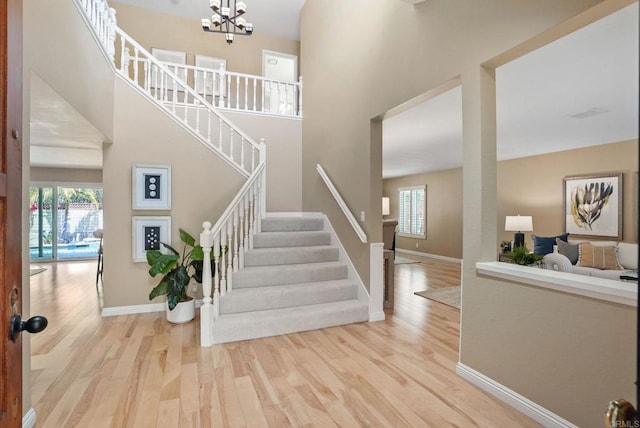 3442 Celinda Dr, Carlsbad, CA 92008 - stairs with wood finished floors, a chandelier, and a towering ceiling