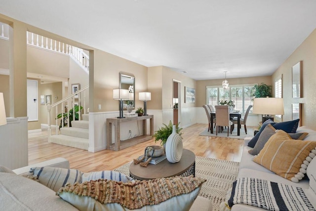 3442 Celinda Dr, Carlsbad, CA 92008 - living room with wood finished floors, a wainscoted wall, a chandelier, and stairs