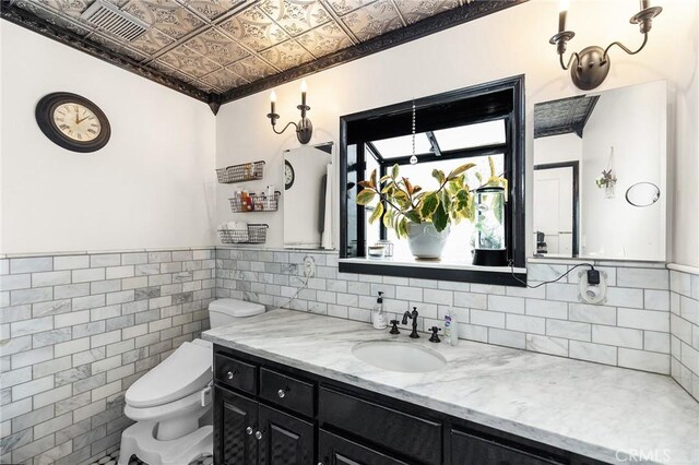 206 S Wisconsin St, Fallbrook, CA 92028 - half bath with an ornate ceiling, tile walls, toilet, and vanity