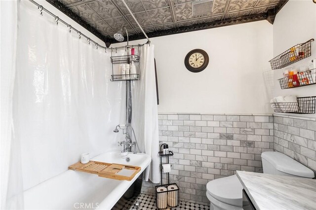 206 S Wisconsin St, Fallbrook, CA 92028 - full bathroom with an ornate ceiling, toilet, tile walls, shower / bathtub combination with curtain, and wainscoting