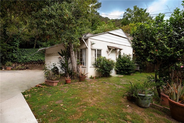 1731 Roscomare Rd, Los Angeles, CA 90077 - view of property exterior featuring driveway, a lawn, and stucco siding
