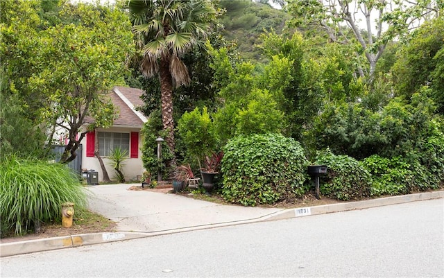1731 Roscomare Rd, Los Angeles, CA 90077 - view of property hidden behind natural elements with roof with shingles and stucco siding