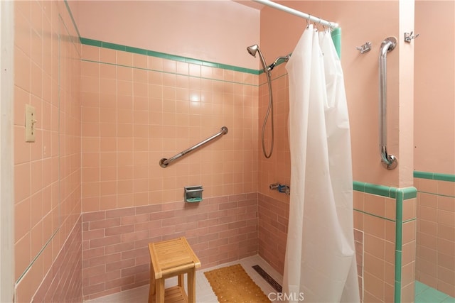1731 Roscomare Rd, Los Angeles, CA 90077 - full bathroom featuring tiled shower, tile walls, and wainscoting