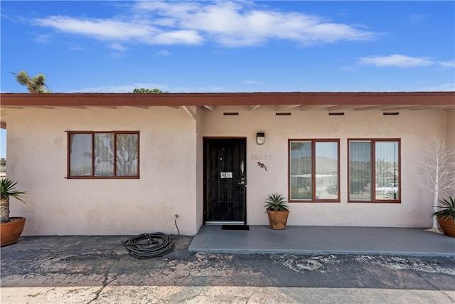 56287 Navajo Trl, Yucca Valley, CA 92284 - doorway to property with stucco siding