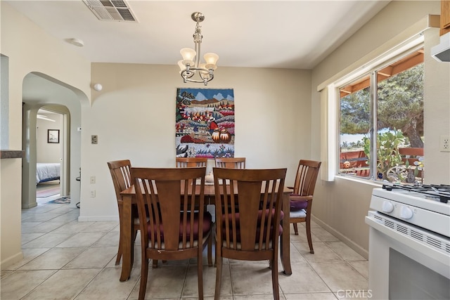 56287 Navajo Trl, Yucca Valley, CA 92284 - dining space featuring light tile patterned floors, a chandelier, arched walkways, and baseboards