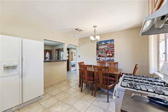 56287 Navajo Trl, Yucca Valley, CA 92284 - dining space featuring arched walkways, a chandelier, and light tile patterned floors