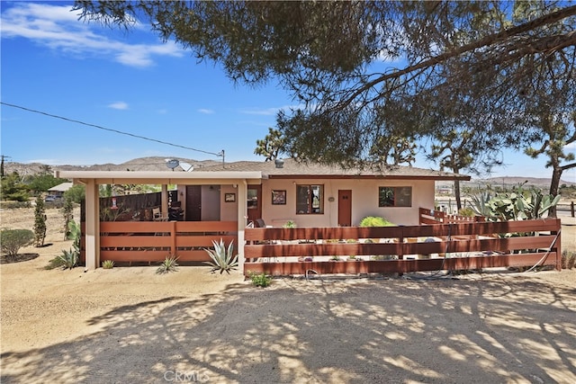 56287 Navajo Trl, Yucca Valley, CA 92284 - single story home featuring a fenced front yard, stucco siding, and a mountain view