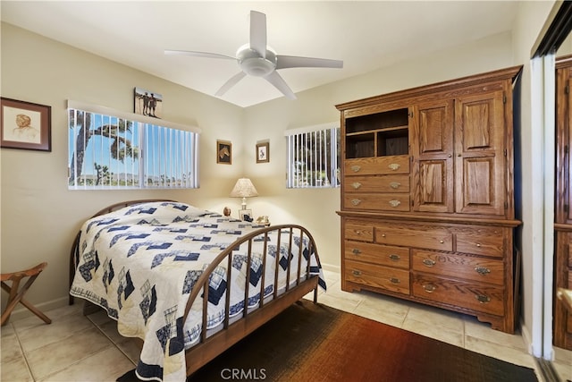 56287 Navajo Trl, Yucca Valley, CA 92284 - bedroom featuring multiple windows, light tile patterned flooring, ceiling fan, and baseboards