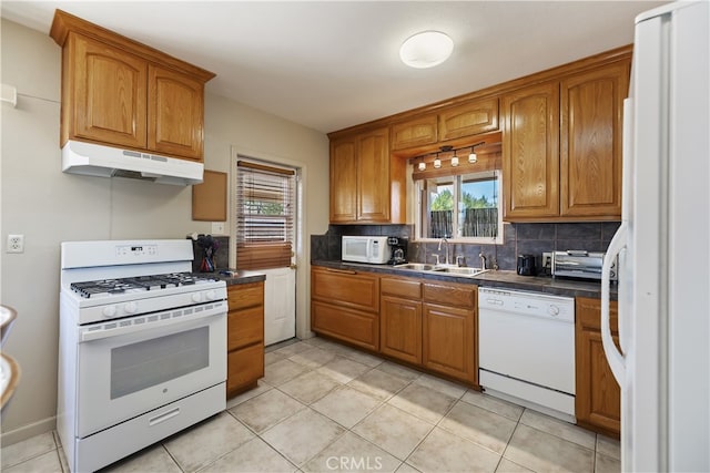 56287 Navajo Trl, Yucca Valley, CA 92284 - kitchen featuring white appliances, under cabinet range hood, a sink, brown cabinets, and tasteful backsplash