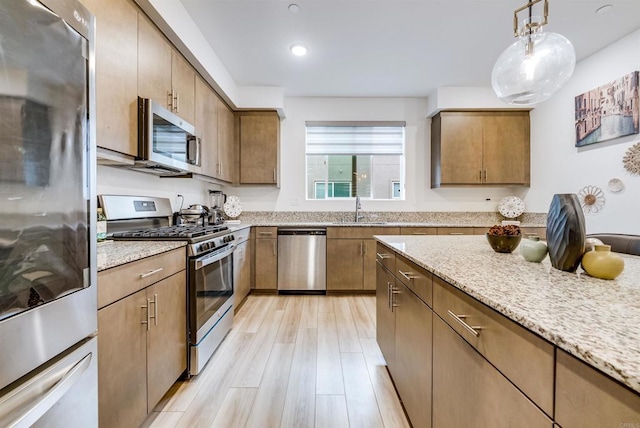 5261 Beachfront Cove St # 174, San Diego, CA 92154 - kitchen featuring stainless steel appliances, a sink, light stone countertops, light wood finished floors, and recessed lighting