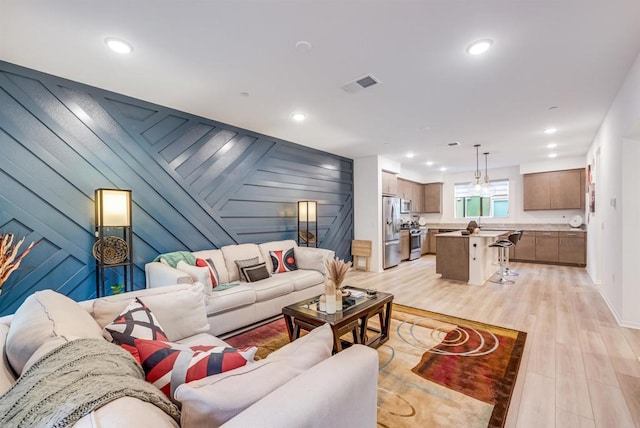 5261 Beachfront Cove St # 174, San Diego, CA 92154 - living area featuring light wood-style flooring, recessed lighting, baseboards, and wooden walls