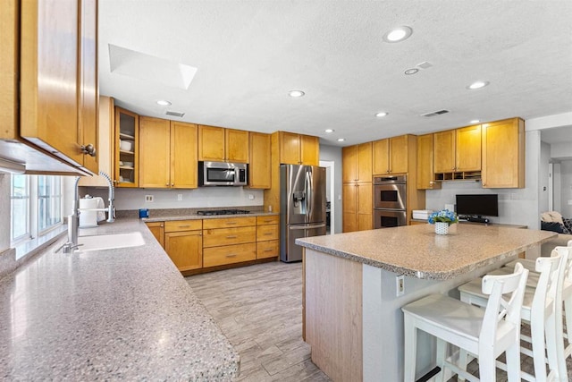 1754 Hill Top Ln, Encinitas, CA 92024 - kitchen with stainless steel appliances, a sink, a skylight, a kitchen breakfast bar, and recessed lighting