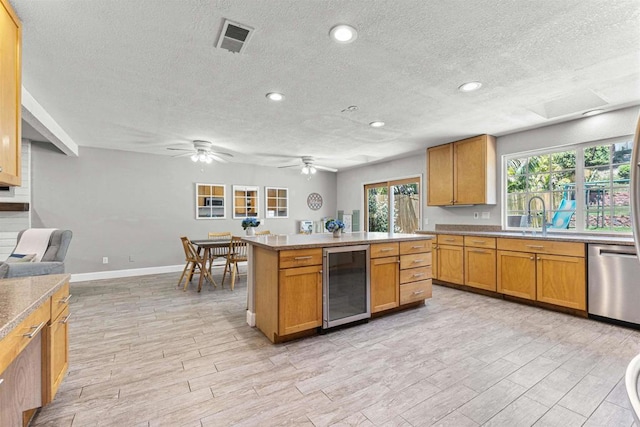 1754 Hill Top Ln, Encinitas, CA 92024 - kitchen with wine cooler, stainless steel dishwasher, a textured ceiling, light wood finished floors, and healthy amount of natural light