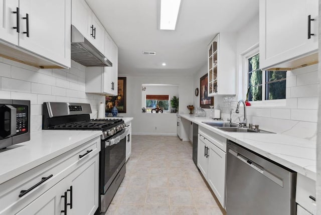 13808 Pomerado Rd, Poway, CA 92064 - kitchen with stainless steel appliances, under cabinet range hood, a sink, baseboards, and white cabinets