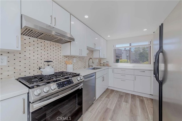 28012 Ridgeforest Ct, Rancho Palos Verdes, CA 90275 - kitchen with stainless steel appliances, under cabinet range hood, light countertops, white cabinets, and a sink