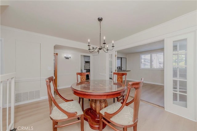 28012 Ridgeforest Ct, Rancho Palos Verdes, CA 90275 - dining room featuring a chandelier, light wood-type flooring, ornamental molding, and arched walkways