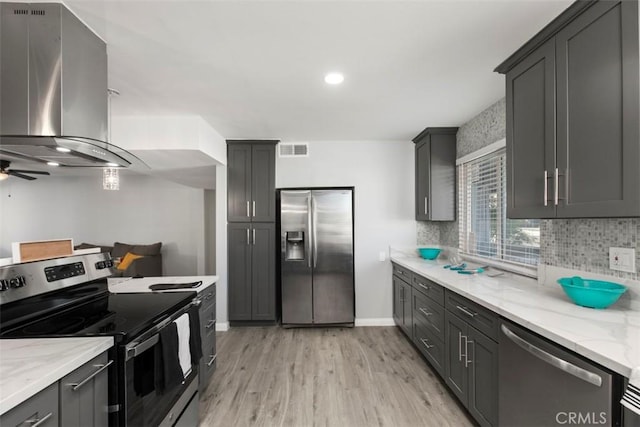 25781 Interlechen Dr, Menifee, CA 92586 - kitchen with stainless steel appliances, range hood, light wood-style floors, tasteful backsplash, and light stone counters