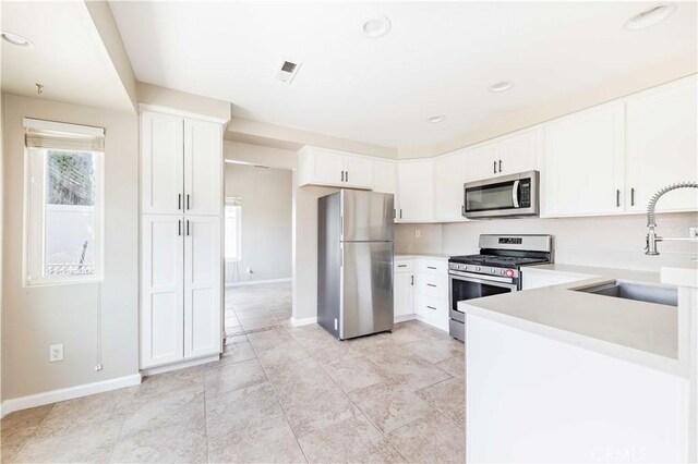 24701 New Haven Dr, Murrieta, CA 92562 - kitchen featuring stainless steel appliances, a sink, baseboards, light countertops, and recessed lighting