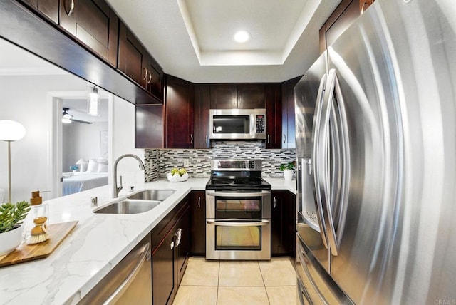 3078 Broadway Unit 210, San Diego, CA 92102 - kitchen featuring appliances with stainless steel finishes, a sink, light tile patterned flooring, backsplash, and light stone countertops
