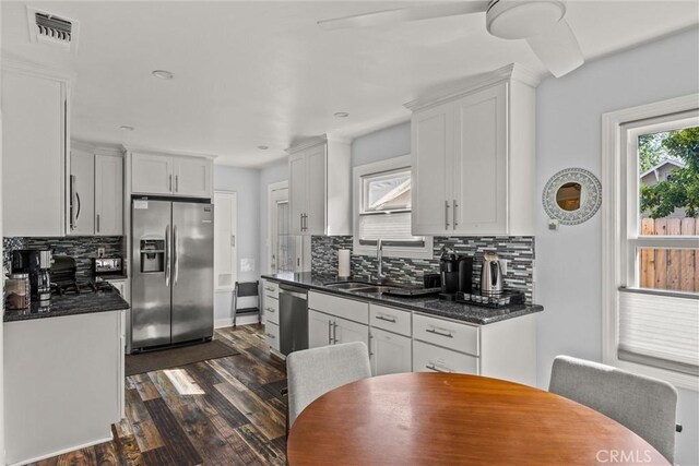 225 W 12th St, Chico, CA 95928 - kitchen featuring appliances with stainless steel finishes, dark wood-style floors, backsplash, white cabinets, and a sink
