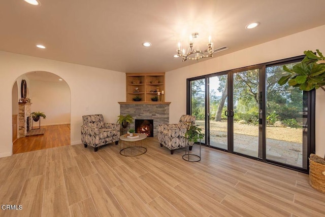 1068 Cuyama Rd, Ojai, CA 93023 - living room featuring a warm lit fireplace, arched walkways, recessed lighting, light wood-type flooring, and a chandelier