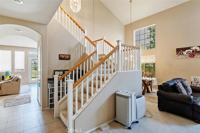 11884 Mariposa Bay Ln, Porter Ranch, CA 91326 - stairs featuring high vaulted ceiling, arched walkways, and tile patterned flooring