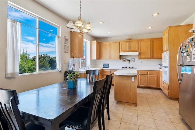 11884 Mariposa Bay Ln, Porter Ranch, CA 91326 - kitchen with white appliances, under cabinet range hood, a chandelier, a center island, and light countertops
