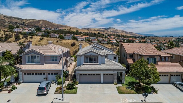 11884 Mariposa Bay Ln, Porter Ranch, CA 91326 - traditional-style house featuring a residential view, concrete driveway, an attached garage, a mountain view, and stucco siding