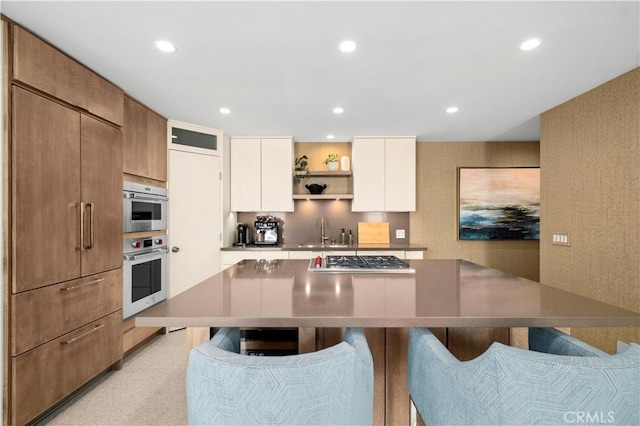 741 Avocado Ave Unit 101, Corona Del Mar, CA 92625 - kitchen with stainless steel gas stovetop, a sink, open shelves, a kitchen bar, and recessed lighting