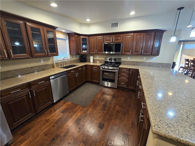249 Loyola Rd, Costa Mesa, CA 92626 - kitchen with stainless steel appliances, a sink, dark wood finished floors, dark brown cabinetry, and light stone counters