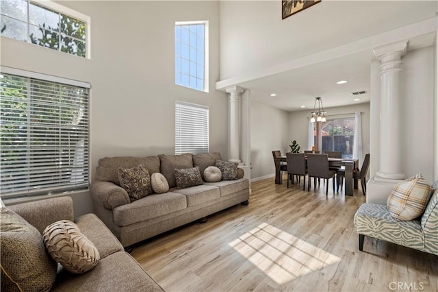 3314 Sandstone Ct, Palmdale, CA 93551 - living area with decorative columns, light wood-style flooring, a towering ceiling, a chandelier, and baseboards