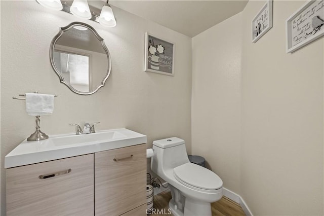 3314 Sandstone Ct, Palmdale, CA 93551 - half bathroom featuring vanity, toilet, wood finished floors, and baseboards
