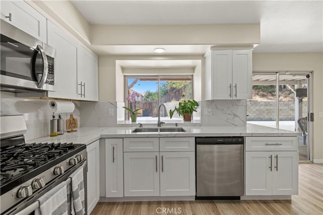 3314 Sandstone Ct, Palmdale, CA 93551 - kitchen with appliances with stainless steel finishes, a sink, light wood-style floors, and healthy amount of natural light