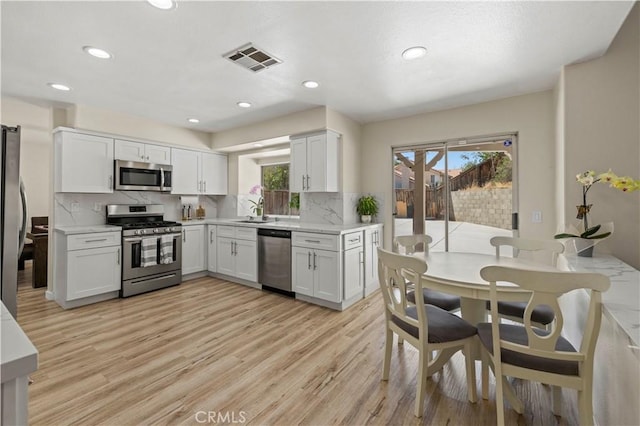 3314 Sandstone Ct, Palmdale, CA 93551 - kitchen with stainless steel appliances, healthy amount of natural light, light wood finished floors, tasteful backsplash, and recessed lighting