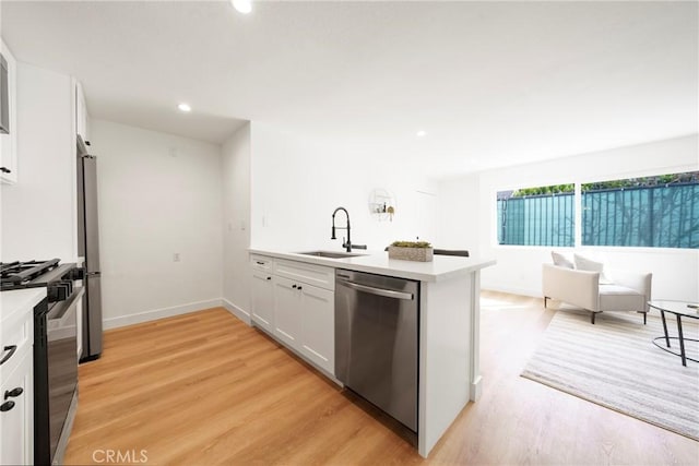 957 S Gramercy Dr Unit 105, Los Angeles, CA 90019 - kitchen with stainless steel appliances, a sink, a peninsula, light countertops, and recessed lighting