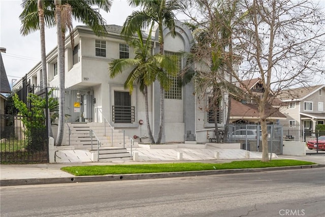 957 S Gramercy Dr Unit 105, Los Angeles, CA 90019 - view of front facade with stucco siding and a gate
