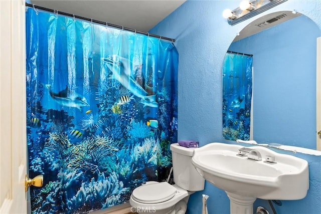 1524 Keko St, Oroville, CA 95965 - full bathroom featuring toilet, a textured wall, a shower with curtain, and a sink