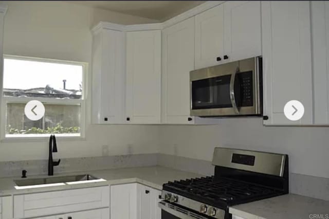 12426 Oaklawn Ave, Chula Vista, CA 91910 - kitchen featuring stainless steel appliances, white cabinets, and light countertops