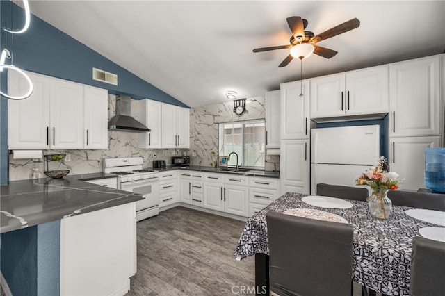 24457 Liolios Way, Moreno Valley, CA 92551 - kitchen with wall chimney exhaust hood, white appliances, lofted ceiling, dark countertops, and a sink