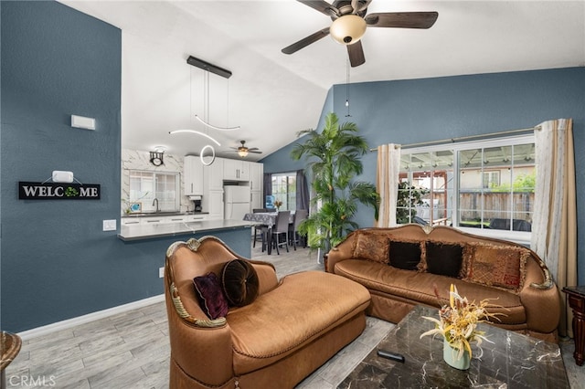 24457 Liolios Way, Moreno Valley, CA 92551 - living area with a ceiling fan, vaulted ceiling, light wood-style floors, and baseboards